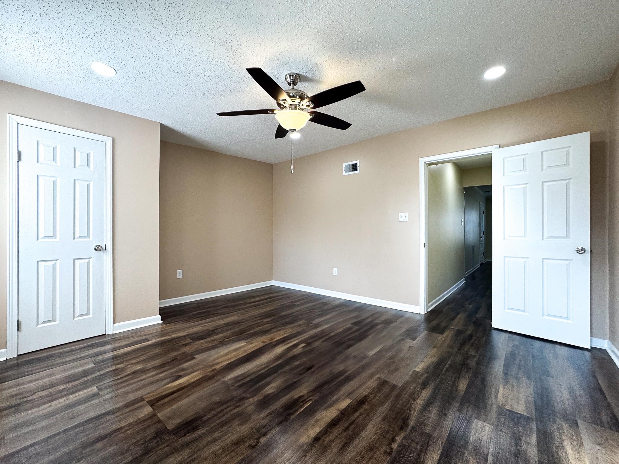 842 Rock Road Memphis, TN 38122 - Photo 6 of 26 Unfurnished bedroom with visible vents, baseboards, a textured ceiling, and dark wood-style flooring