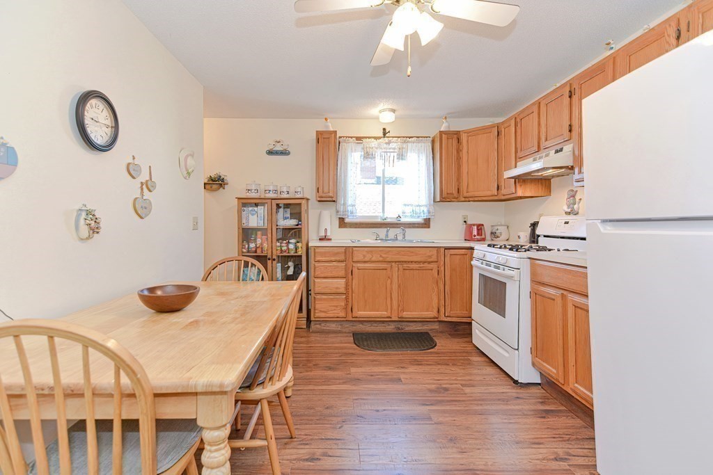 29 Winter Street Fall River, MA 02720 - Photo 11 of 34 a kitchen with stainless steel appliances granite countertop a stove a sink dishwasher and white cabinets with wooden floor