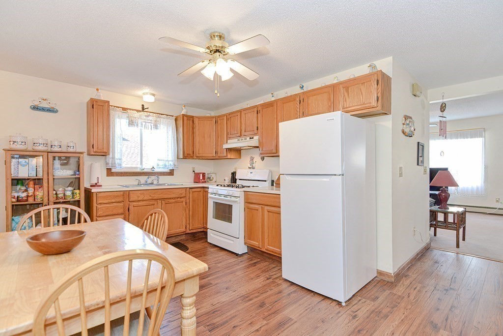 29 Winter Street Fall River, MA 02720 - Photo 10 of 34 a kitchen with stainless steel appliances granite countertop a refrigerator a stove a sink and white cabinets with wooden floor