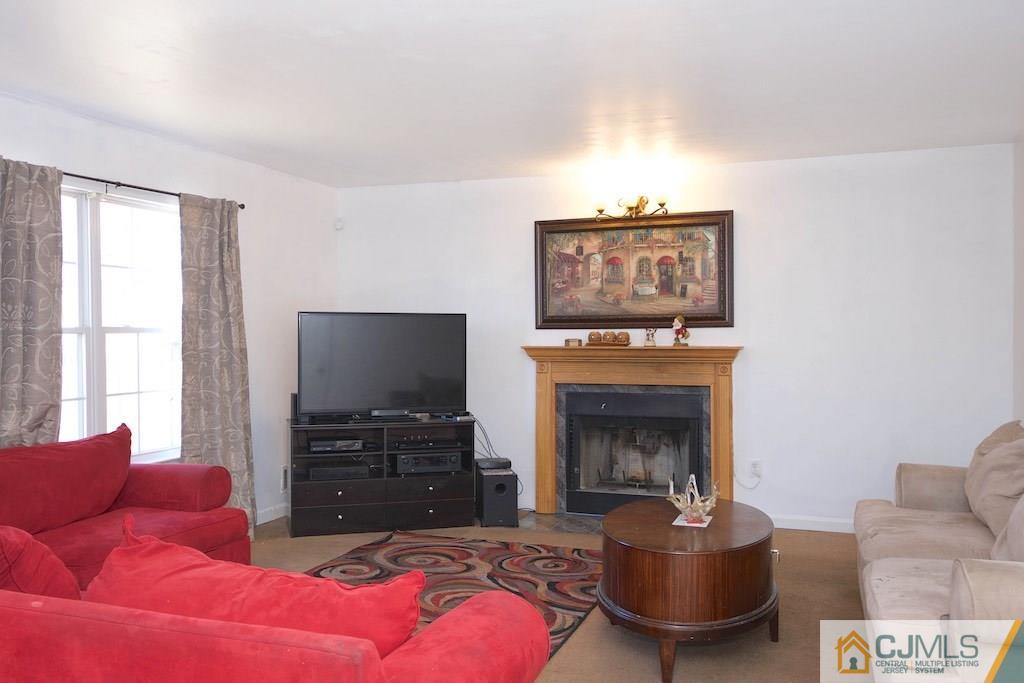 98 New Brooklyn Road Edison, NJ 08817 - Photo 9 of 21 a living room with furniture a flat screen tv and a fireplace