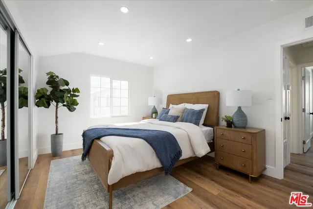 a bedroom with a bed and a potted plant