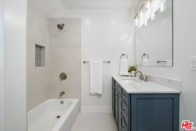 a bathroom with a tub sink and mirror