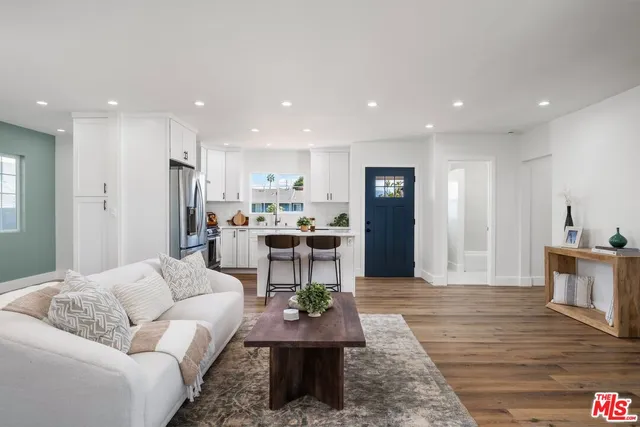a living room with furniture and a dining table with kitchen view