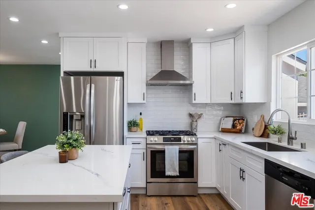 a kitchen with stainless steel appliances a white stove top oven a sink and cabinets