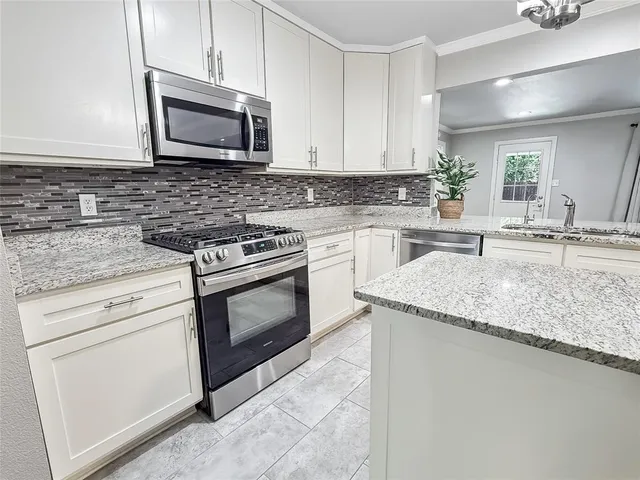 a kitchen with granite countertop cabinets stainless steel appliances and a sink