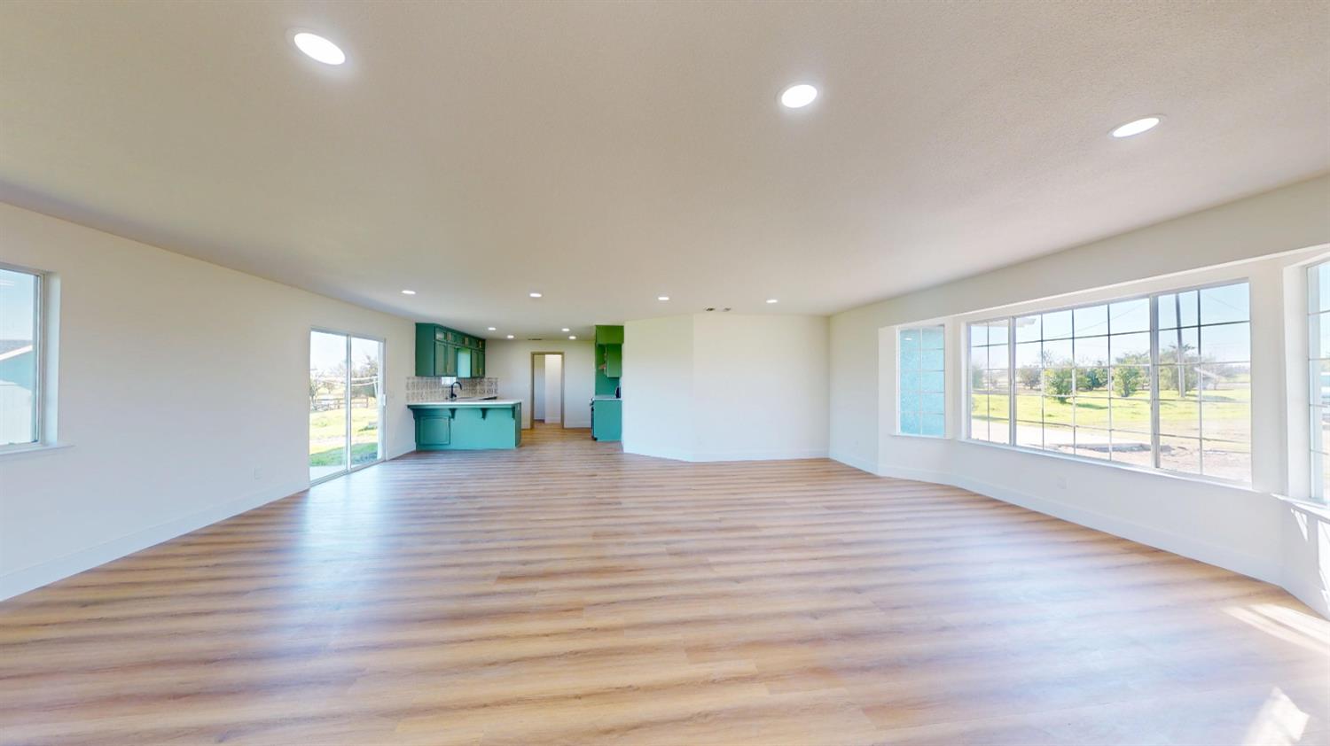 16363 Paula Road Madera, CA 93636 - Photo 12 of 30 a view of an empty room with wooden floor and a window