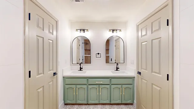 a spacious bathroom with a double vanity sink and a mirror