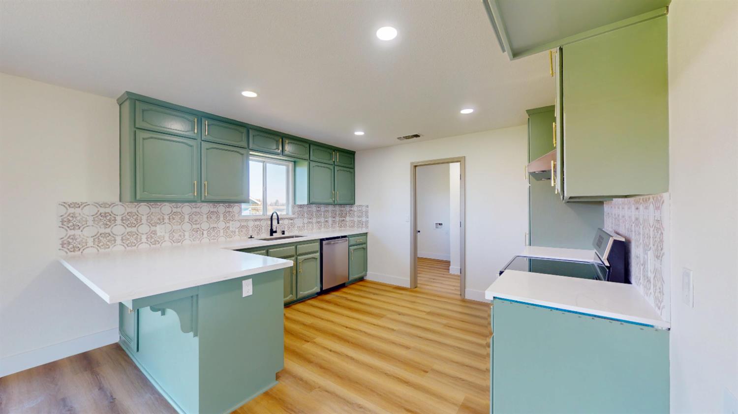16363 Paula Road Madera, CA 93636 - Photo 5 of 30 a kitchen with a sink and a stove top oven with wooden floor
