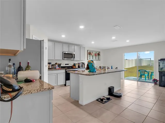 a kitchen with kitchen island granite countertop lots of counter top space and appliances