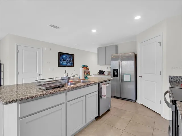 a kitchen with stainless steel appliances granite countertop a refrigerator and a sink