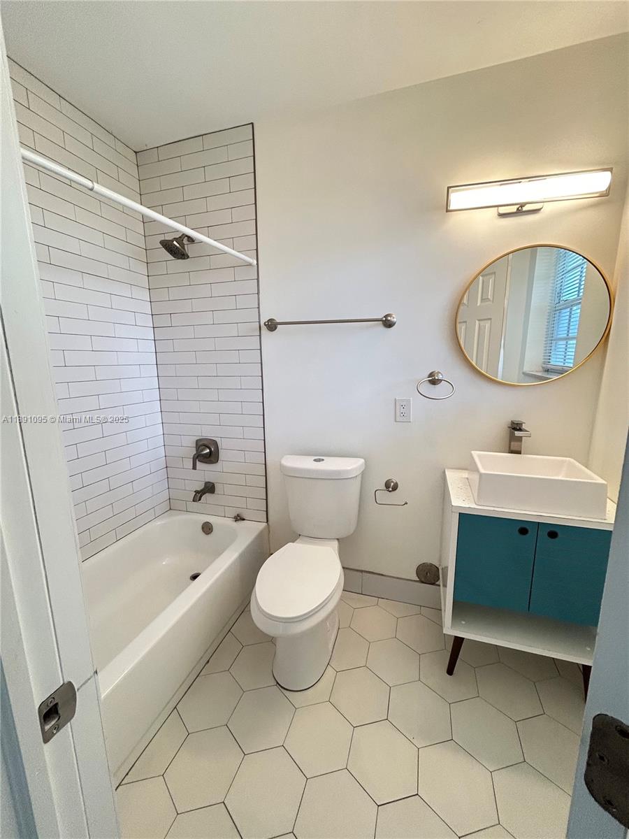 571 Northeast 67th Street, Unit 1 Miami, FL 33138 - Photo 7 of 13 a bathroom with a sink toilet a mirror and shower