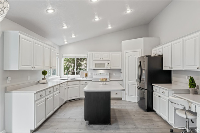 7 Reflection Way St. George, UT 84770 - Photo 12 of 54 Kitchen featuring light countertops, white cabinetry, a center island, white appliances, and recessed lighting