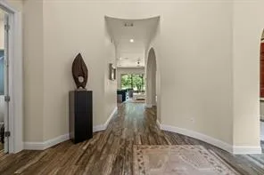 a view of a hallway with wooden floor and a bathroom