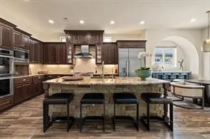 a kitchen with granite countertop a table chairs microwave and cabinets