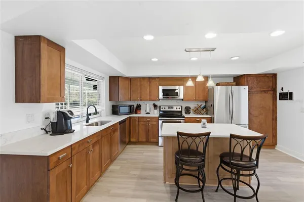 a kitchen with stainless steel appliances kitchen island granite countertop a sink and cabinets