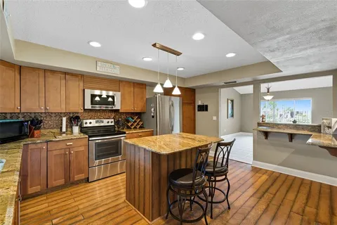 a kitchen with stainless steel appliances granite countertop sink stove and refrigerator