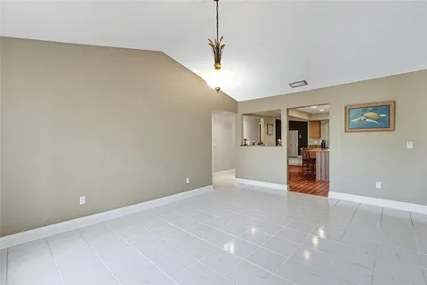 a large bed sitting in a bedroom next to a window with a chandelier