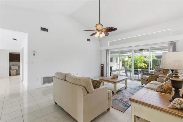 a living room with furniture a flat screen tv and a large window