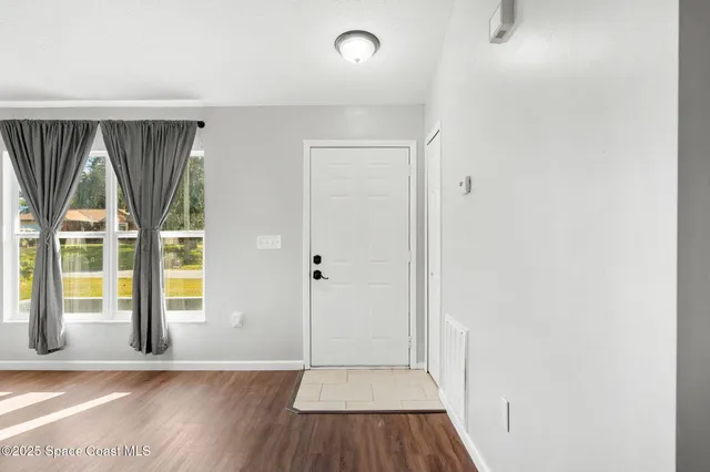 a living room with furniture a bed and a large window