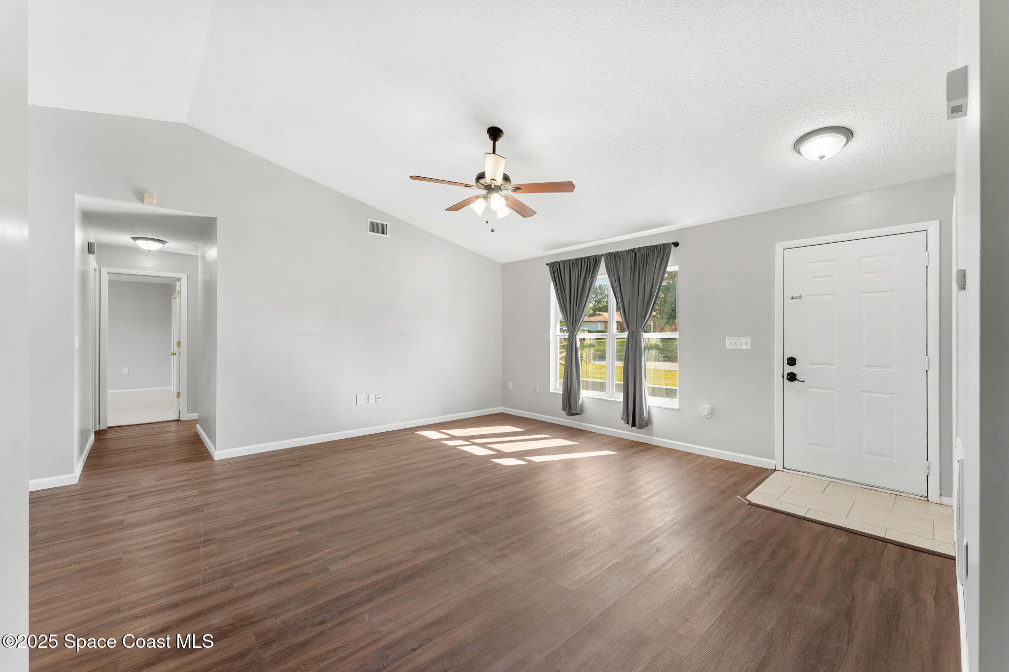 4852 Alfred Street Cocoa, FL 32927 - Photo 15 of 59 a view of an empty room with wooden floor and a window