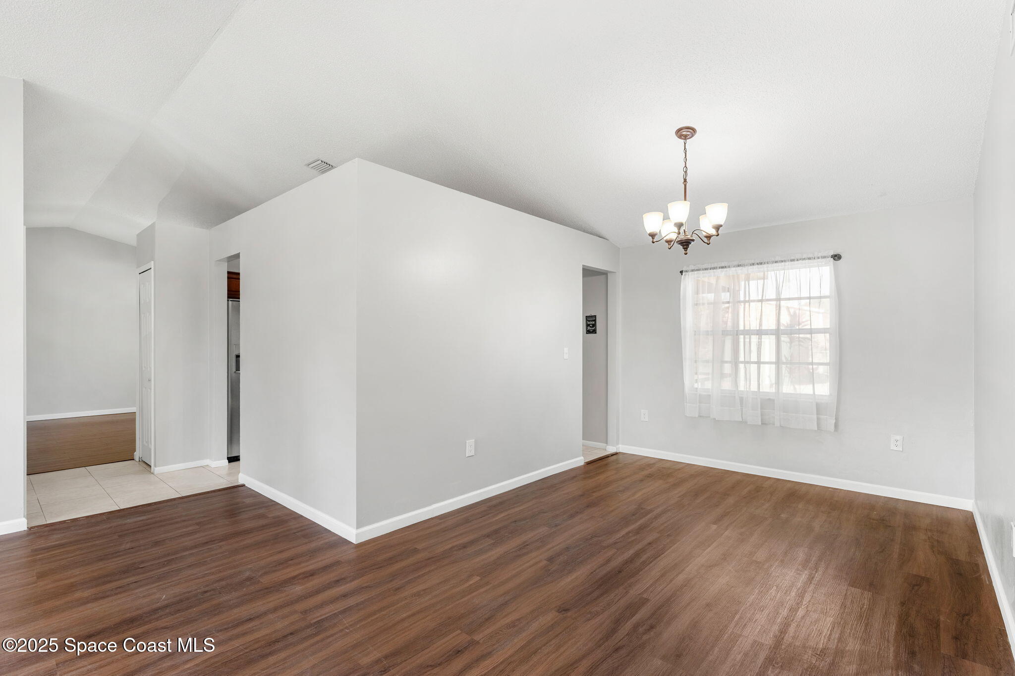 4852 Alfred Street Cocoa, FL 32927 - Photo 21 of 59 a view of an empty room with wooden floor and a window