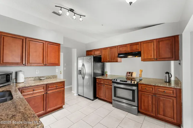 a kitchen with granite countertop a sink stove and cabinets