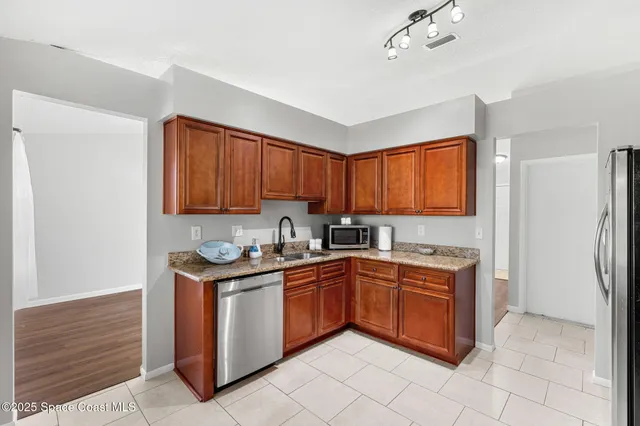 a kitchen with stainless steel appliances granite countertop a stove a sink and a refrigerator