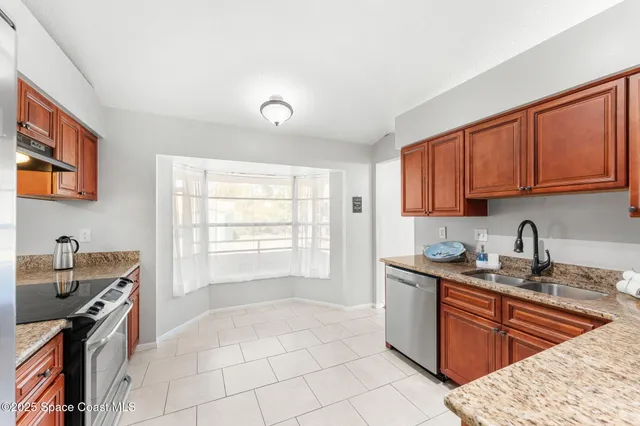 a kitchen with stainless steel appliances granite countertop a stove sink and cabinets