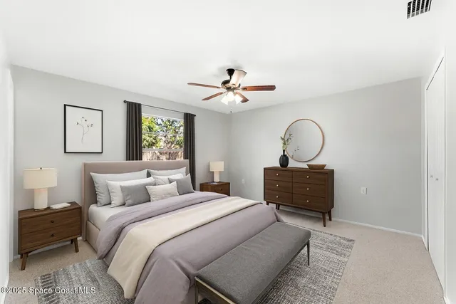 an empty room with windows and chandelier fan