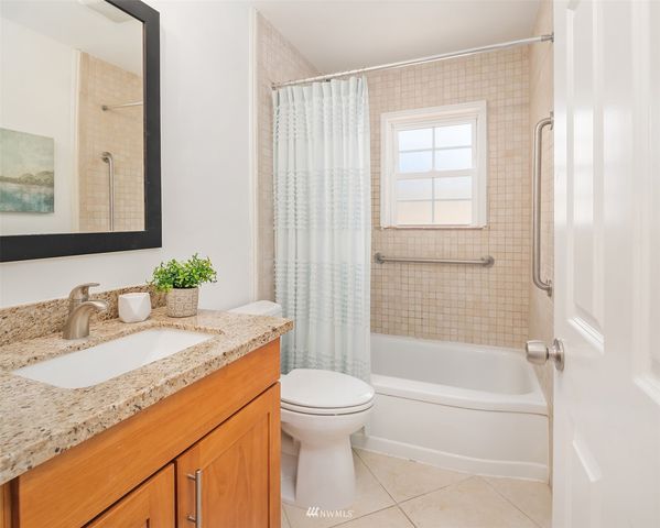 a bathroom with a granite countertop sink a toilet and shower