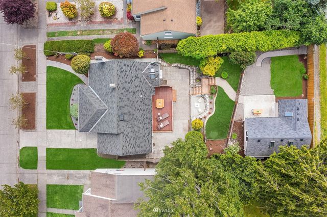 an aerial view of a house with a yard and tennis court