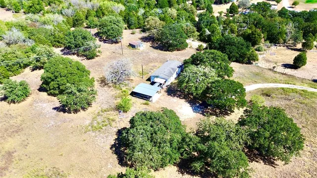 an aerial view of residential houses with yard and green space