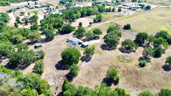 an aerial view of a residential houses with yard and lake view in back