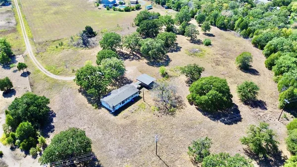 an aerial view of a house with a yard and lake view