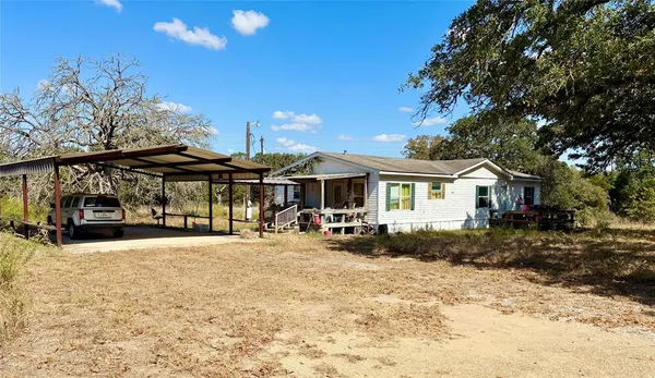 a view of a house with a yard and sitting area