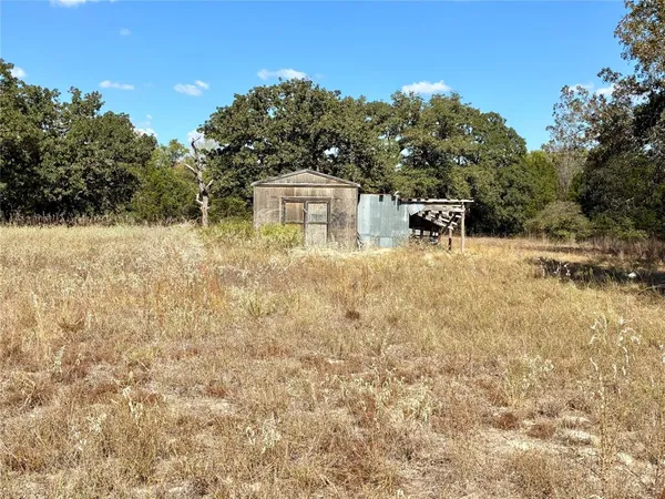 a view of a dry yard with wooden fence