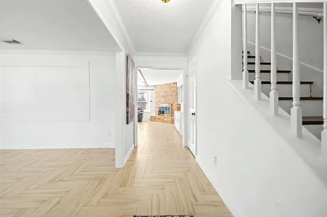a view of a hallway with wooden floor and staircase