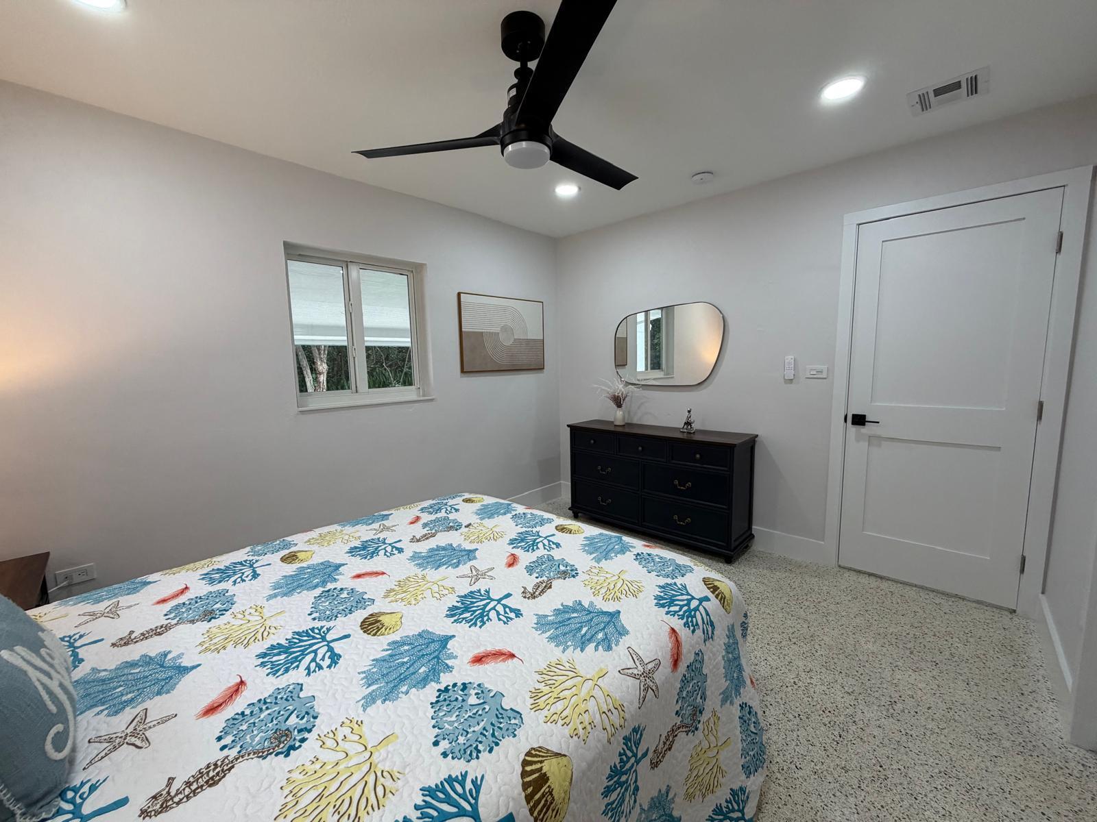 219 South Bay Harbor Drive, Unit A Key Largo, FL 33037 - Photo 13 of 18 a bedroom with a bed and a chandelier