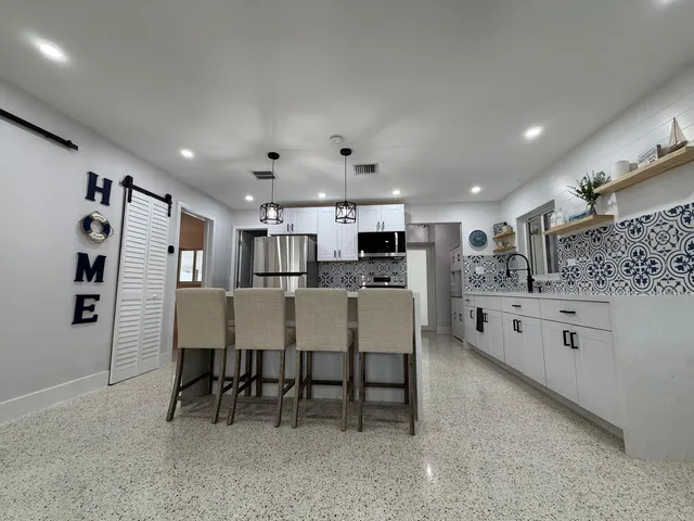 a kitchen with white cabinets and stainless steel appliances
