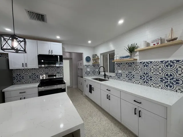 a kitchen with white cabinets and stainless steel appliances