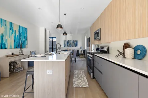 a large kitchen with kitchen island a sink stove and cabinets