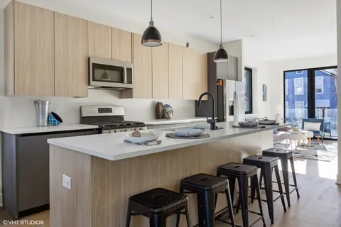 a kitchen with a sink stainless steel appliances and white cabinets