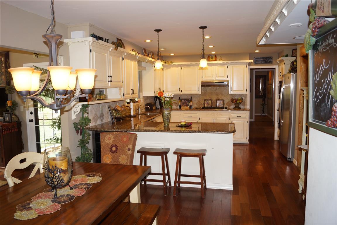 14388 Fern Road Whitmore, CA 96096 - Photo 17 of 52 a dining room with stainless steel appliances kitchen island granite countertop a table chairs and a refrigerator
