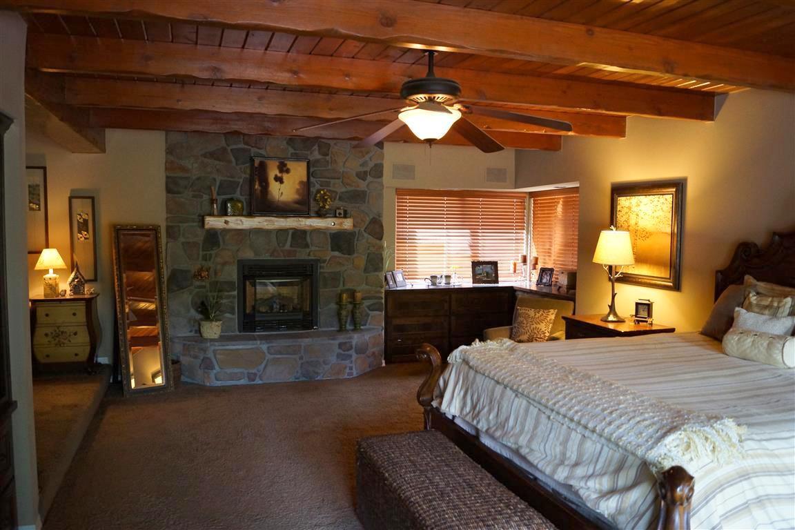 14388 Fern Road Whitmore, CA 96096 - Photo 20 of 52 a bedroom with a bed and a chandelier