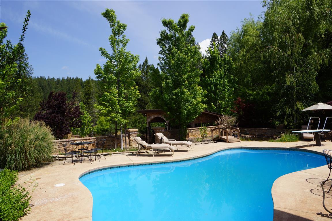 14388 Fern Road Whitmore, CA 96096 - Photo 25 of 52 a view of a swimming pool with chairs and potted plants