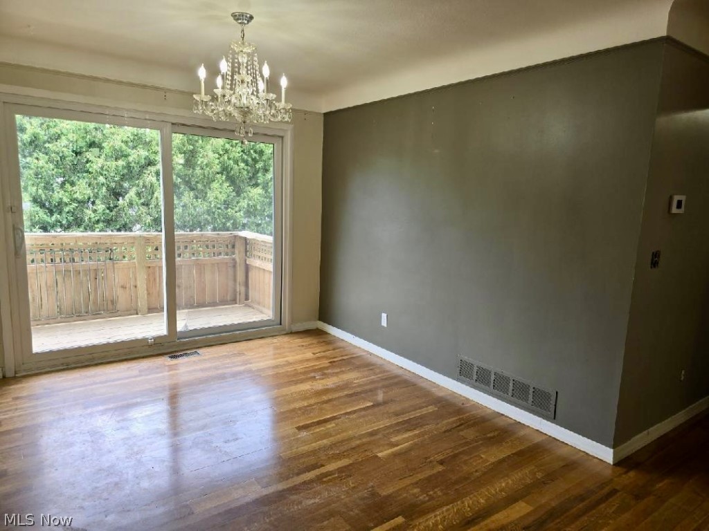 7735 Ragall Parkway Cleveland, OH 44130 - Photo 17 of 32 Empty room featuring a chandelier and hardwood / wood-style floors