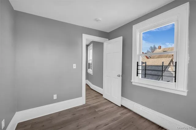 a view of a hallway with wooden floor and a bedroom