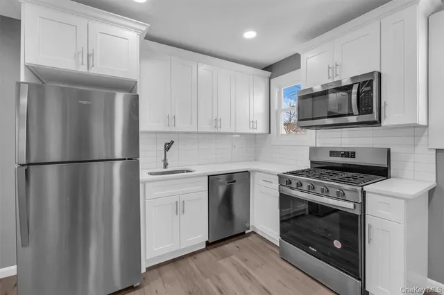a kitchen with stainless steel appliances a stove microwave and refrigerator