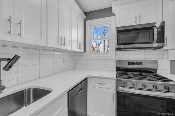 a kitchen with cabinets stainless steel appliances and a counter space