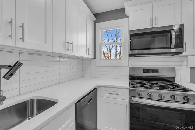 a kitchen with cabinets stainless steel appliances and a counter space